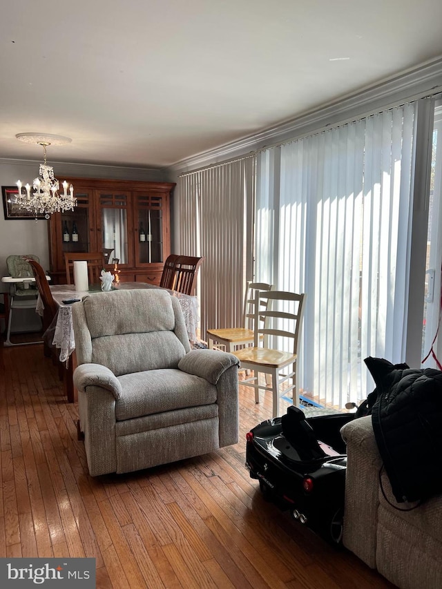 living room featuring an inviting chandelier, hardwood / wood-style flooring, and ornamental molding