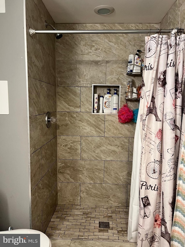 bathroom with a shower with curtain and toilet