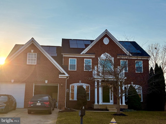 view of front facade featuring driveway, a garage, a front lawn, and brick siding