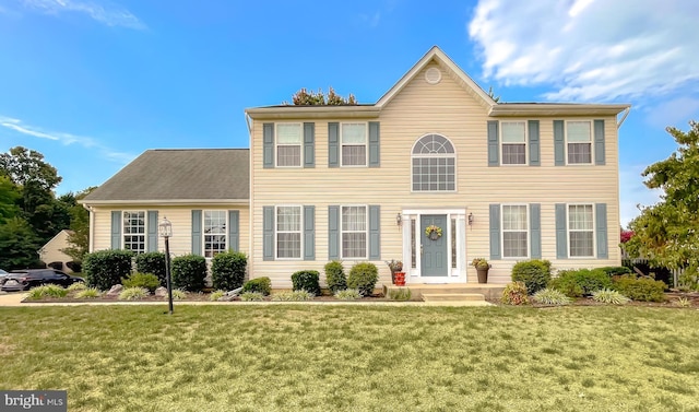 colonial inspired home with a front lawn