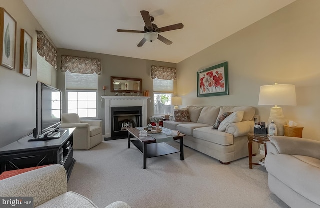 living room featuring a ceiling fan, light carpet, and a fireplace