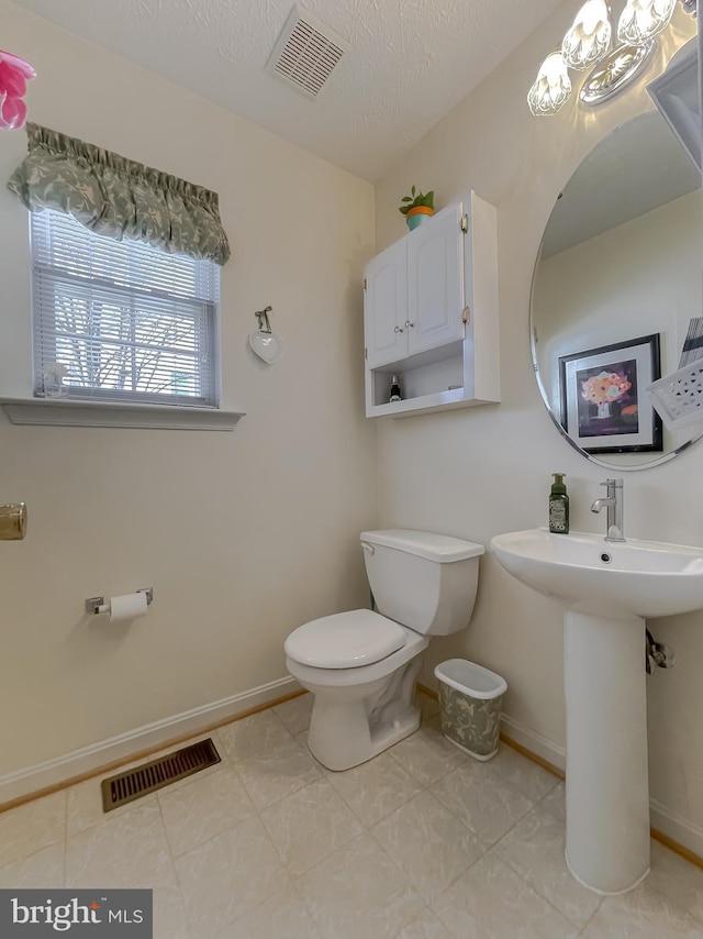 half bathroom featuring baseboards, visible vents, and toilet