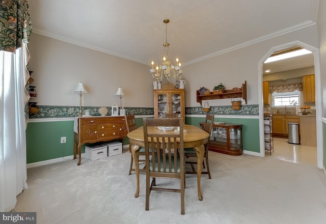 dining room with a notable chandelier, ornamental molding, and light colored carpet