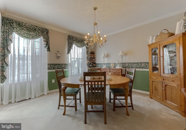 dining area featuring a chandelier, light colored carpet, a wainscoted wall, and crown molding