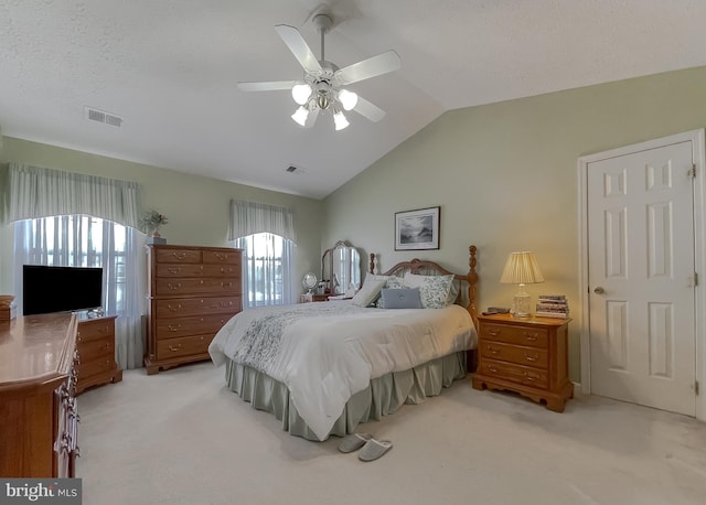 bedroom with vaulted ceiling, visible vents, and light colored carpet