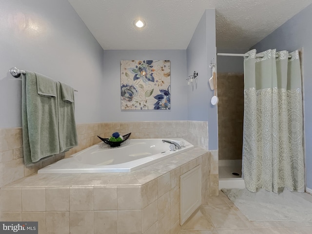 bathroom with a stall shower, tile patterned flooring, a textured ceiling, and a bath