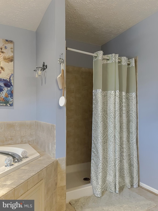 full bath featuring a textured ceiling, a stall shower, tile patterned flooring, and a garden tub