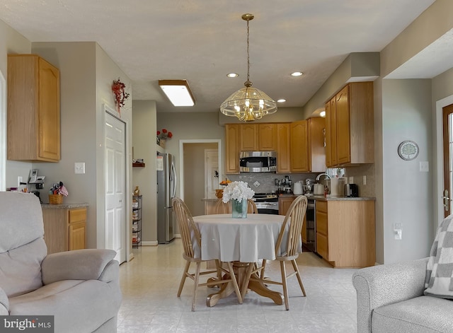 kitchen featuring decorative light fixtures, recessed lighting, backsplash, appliances with stainless steel finishes, and open floor plan