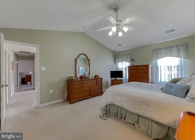 bedroom with light carpet, a textured ceiling, lofted ceiling, and visible vents