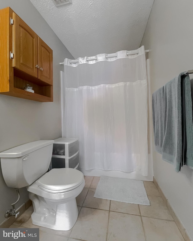 full bath with toilet, shower / bath combo with shower curtain, a textured ceiling, and tile patterned floors