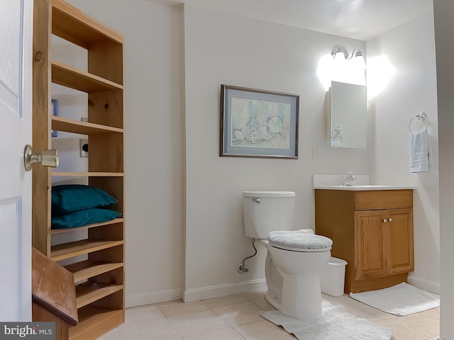 half bath with toilet, vanity, baseboards, and tile patterned floors