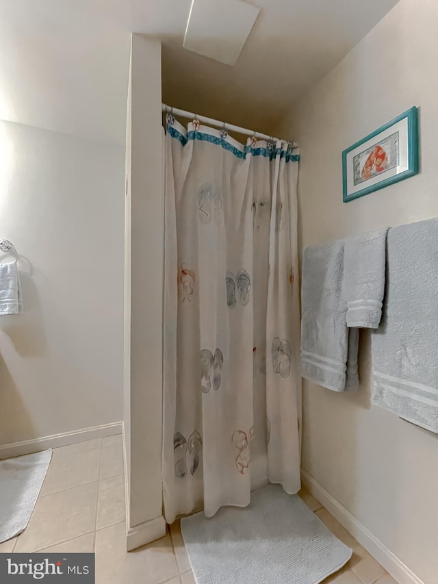 full bath with curtained shower, baseboards, and tile patterned floors