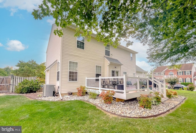 rear view of house with a lawn, fence, a deck, and cooling unit