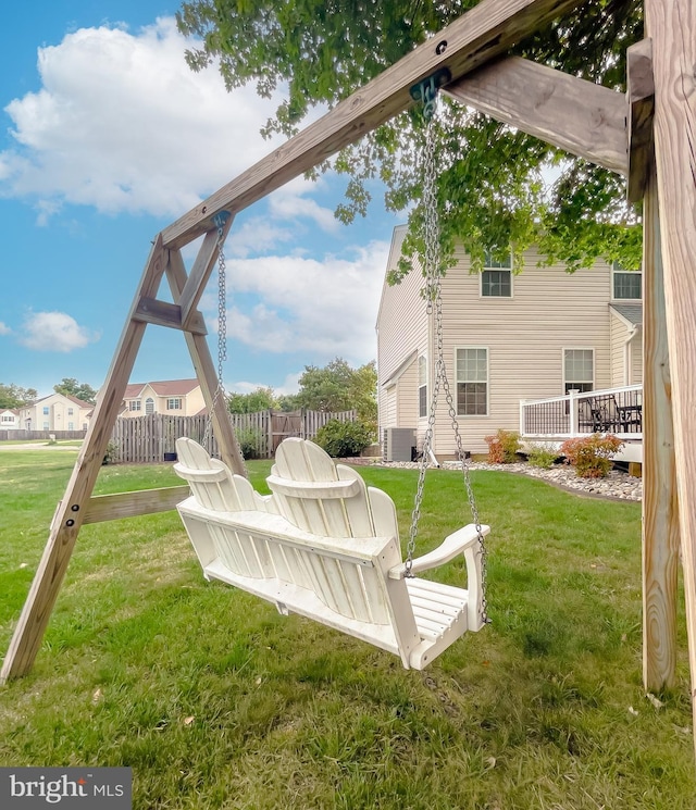 view of yard featuring central AC and fence