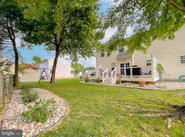 rear view of property featuring a deck and a lawn