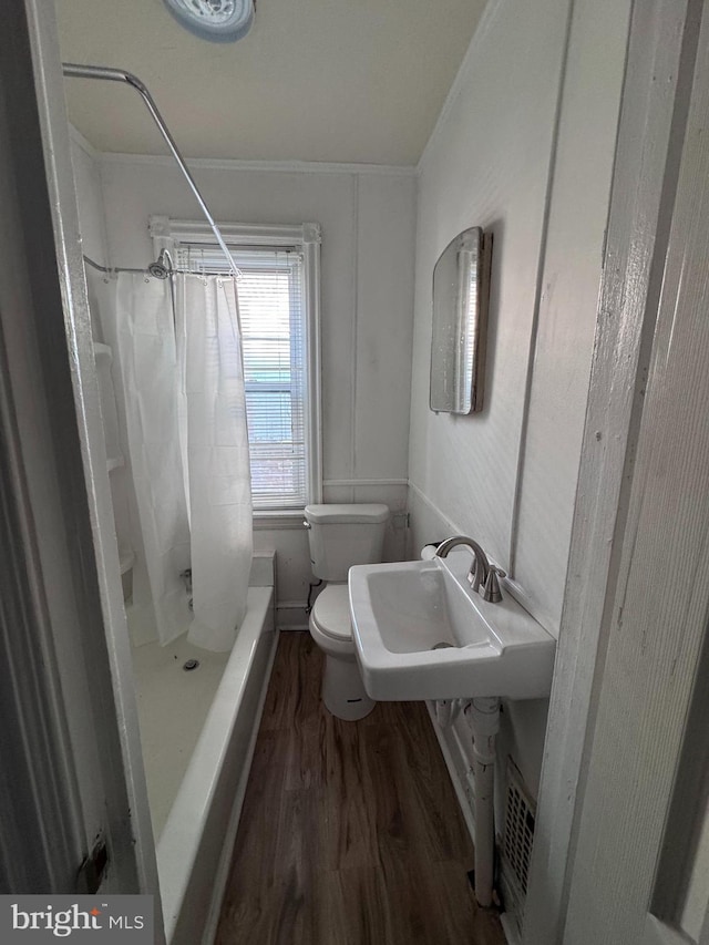 bathroom with ornamental molding, a sink, toilet, and wood finished floors