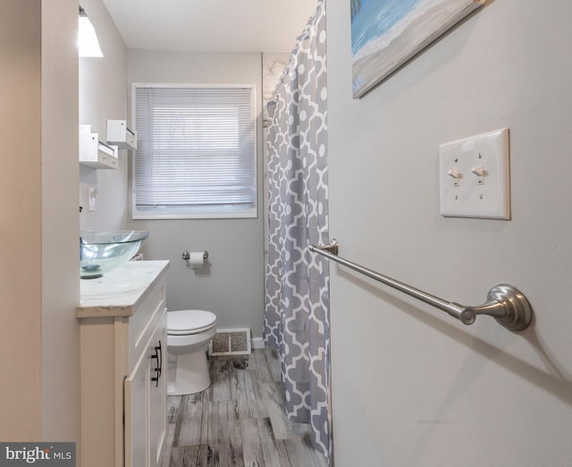 bathroom with wood-type flooring, vanity, and toilet