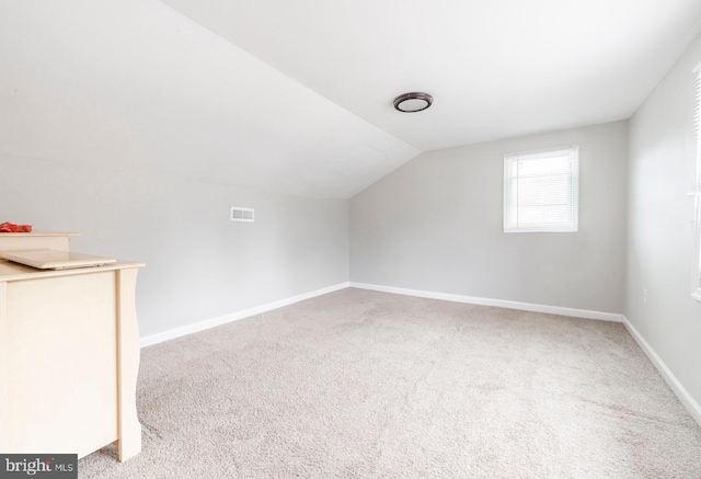 bonus room with vaulted ceiling and carpet