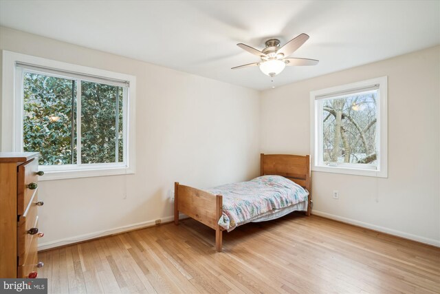 bedroom featuring a ceiling fan, light wood-style flooring, and baseboards