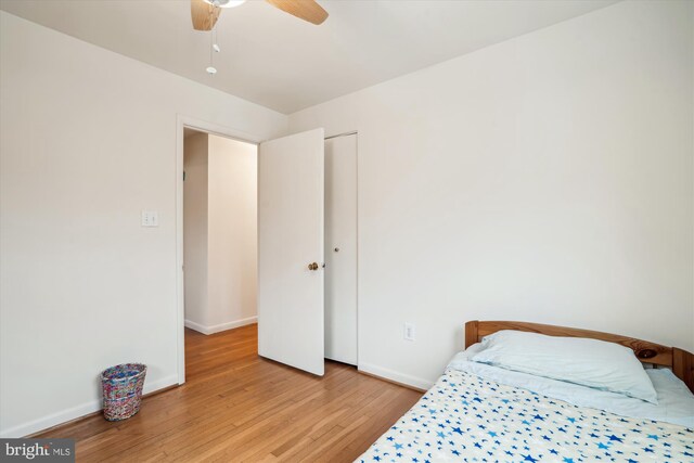 bedroom featuring ceiling fan, light wood-style flooring, and baseboards