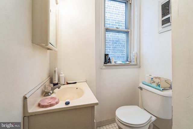 bathroom with vanity, an AC wall unit, and toilet