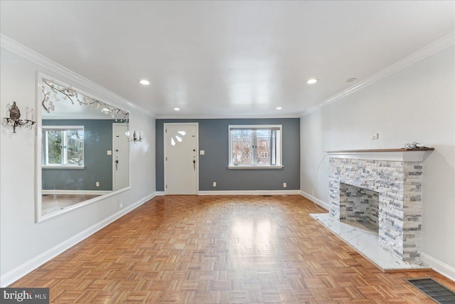 unfurnished living room with light parquet floors, crown molding, a wealth of natural light, and a fireplace