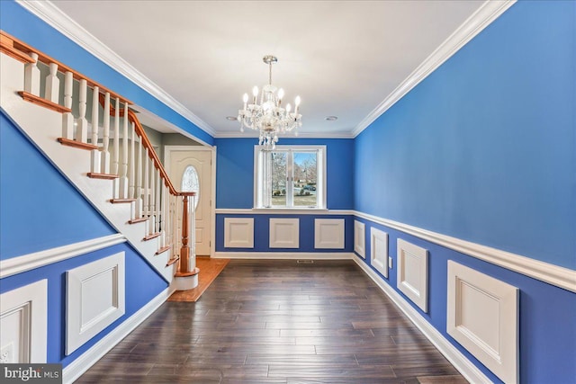 foyer entrance featuring ornamental molding, a notable chandelier, and dark hardwood / wood-style flooring