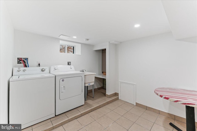 laundry area with independent washer and dryer and light tile patterned floors