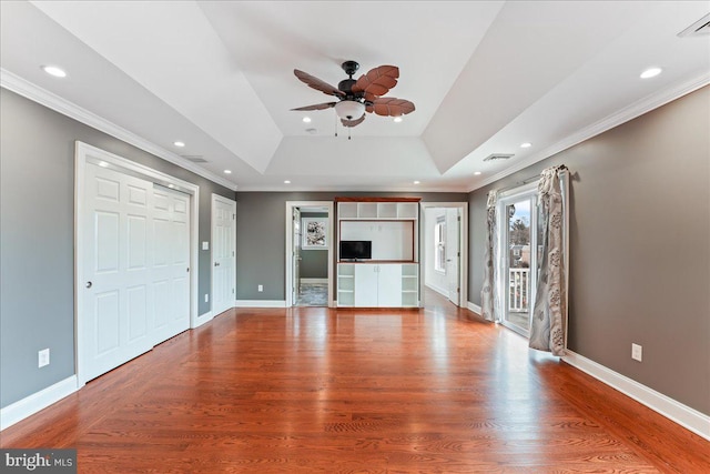 unfurnished living room featuring hardwood / wood-style floors, crown molding, a raised ceiling, and ceiling fan