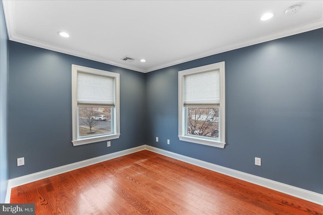 empty room featuring wood-type flooring and ornamental molding