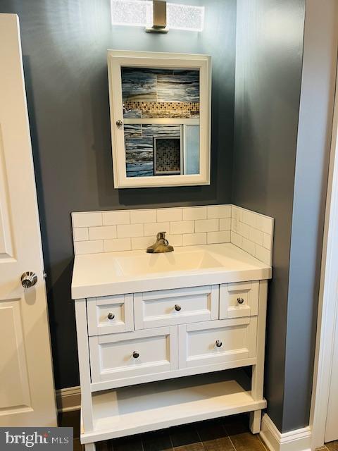 bathroom featuring vanity and backsplash