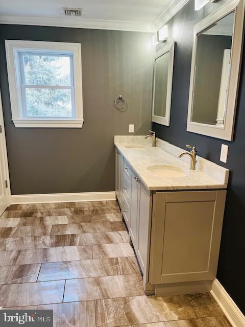 bathroom featuring crown molding and vanity