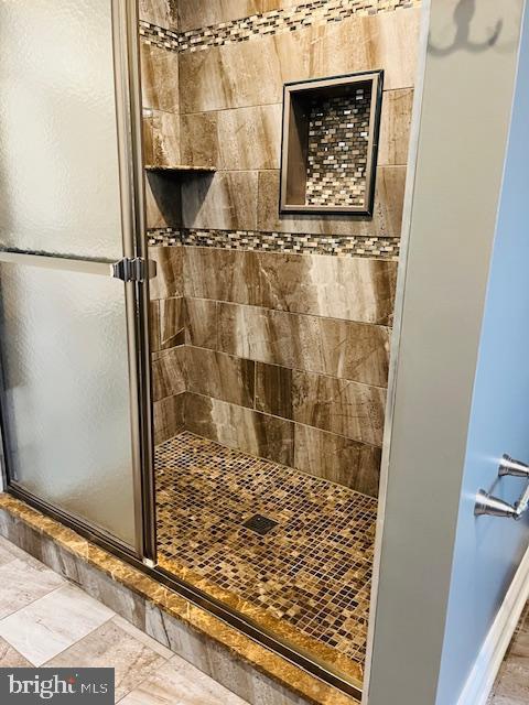 bathroom with a shower with door