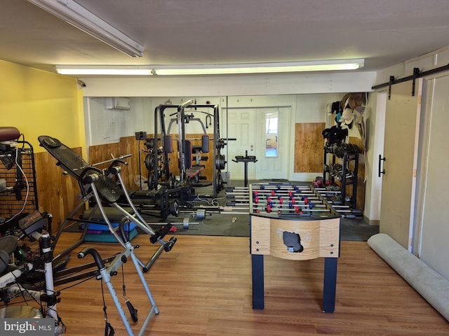 exercise room featuring hardwood / wood-style flooring and a barn door