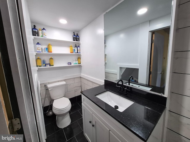 bathroom with vanity, tile walls, tile patterned floors, and toilet