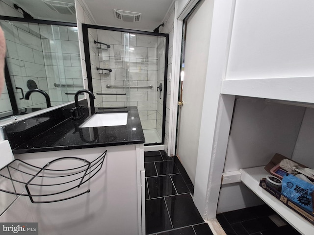 bathroom featuring vanity, a shower with shower door, and tile patterned floors