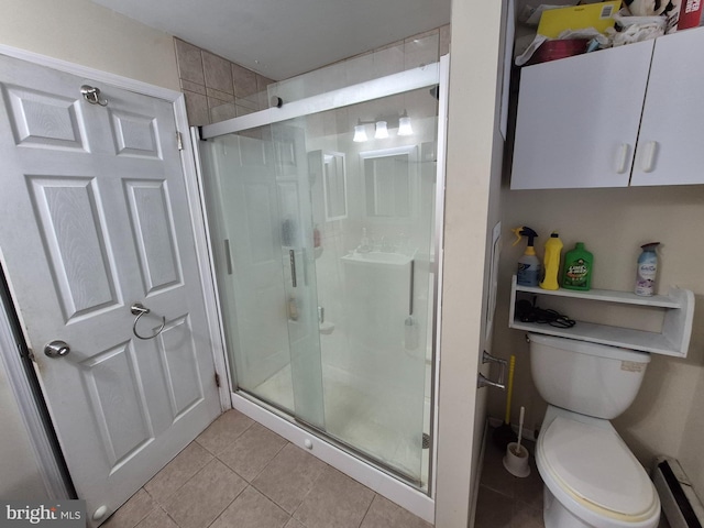 bathroom with toilet, tile patterned flooring, and a shower with door