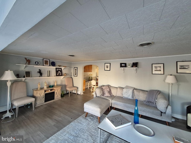 living room with hardwood / wood-style flooring and crown molding