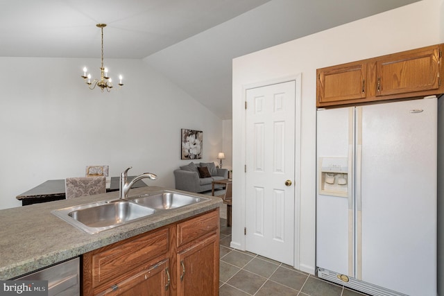 kitchen with sink, decorative light fixtures, vaulted ceiling, dark tile patterned flooring, and white refrigerator with ice dispenser