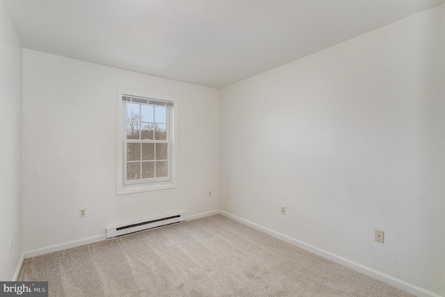 carpeted empty room featuring a baseboard heating unit