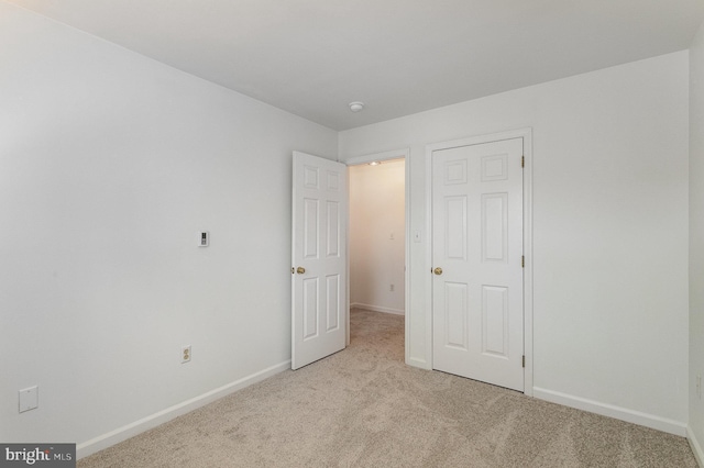 unfurnished bedroom featuring light carpet