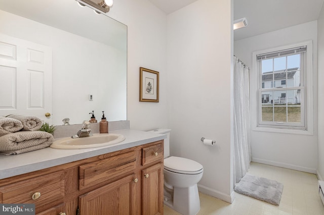 bathroom featuring vanity, toilet, and a baseboard heating unit