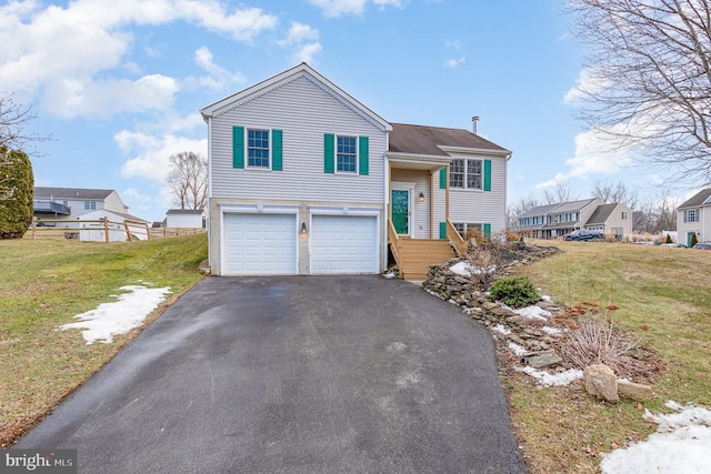 bi-level home with a garage and a front lawn