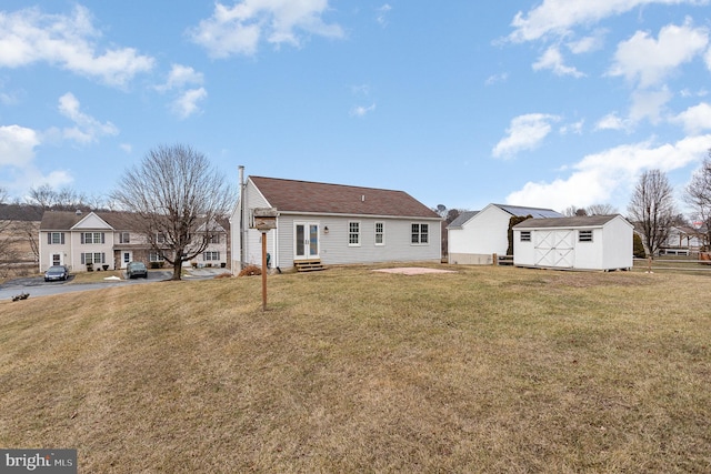 rear view of property with a storage shed and a yard