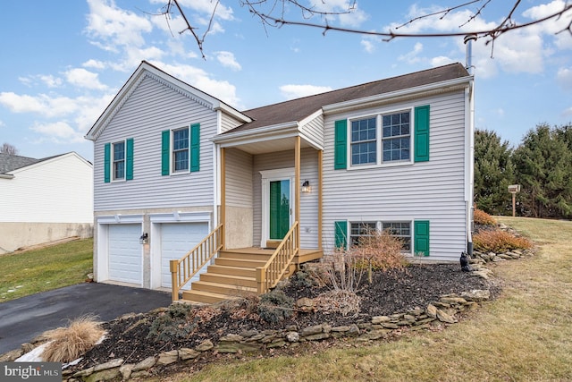 split foyer home featuring a garage and a front lawn