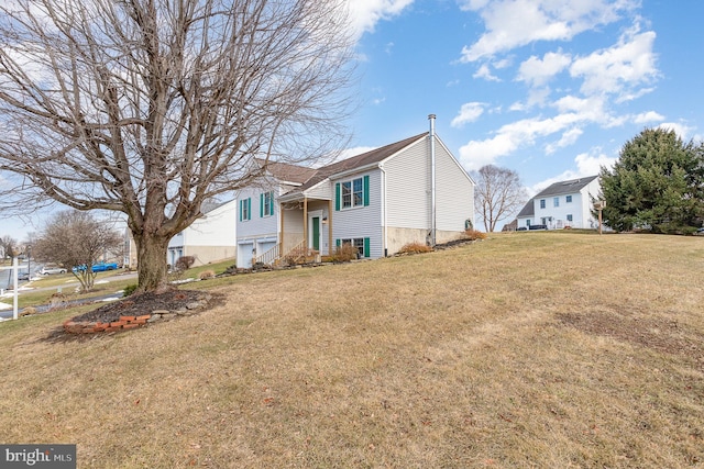 split foyer home with a garage and a front yard