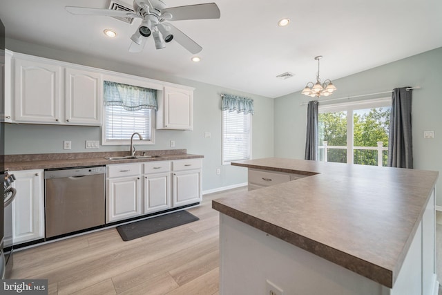 kitchen featuring white cabinetry, sink, stainless steel dishwasher, and decorative light fixtures