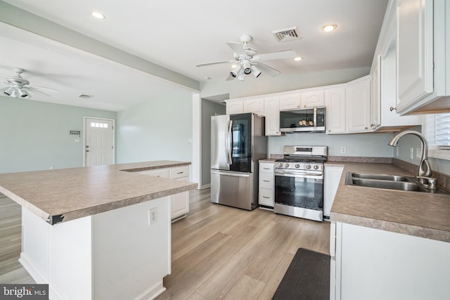 kitchen with white cabinetry, appliances with stainless steel finishes, sink, and light hardwood / wood-style flooring