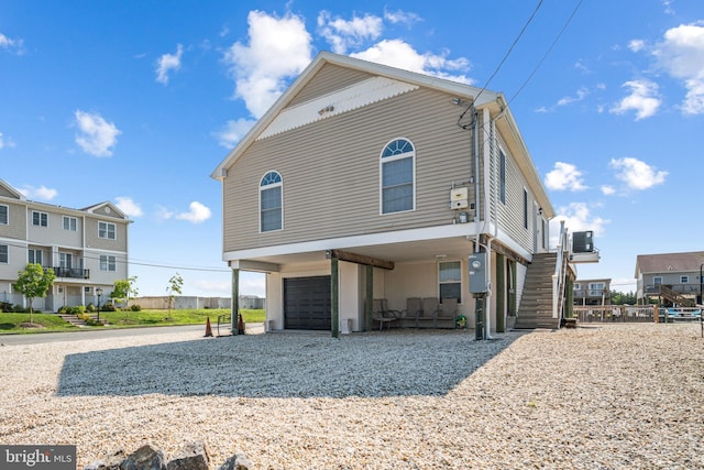 view of front of property with a garage and central AC unit