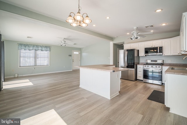 kitchen featuring sink, white cabinetry, decorative light fixtures, ceiling fan, and stainless steel appliances